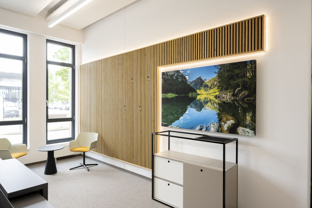 Frameless Picture rahmenloses Akustikbild mit bedrucktem Bergsee-Motiv als Schallschutz vor einer Holzlamellenwand im Büro