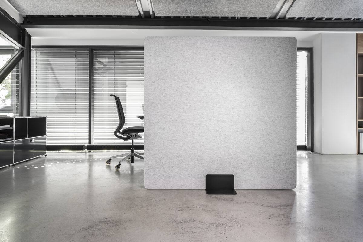 Frameless Move freistehende graue Akustik-Stellwand als Sicht- und Schallschutz neben einem Schreibtisch im Büro