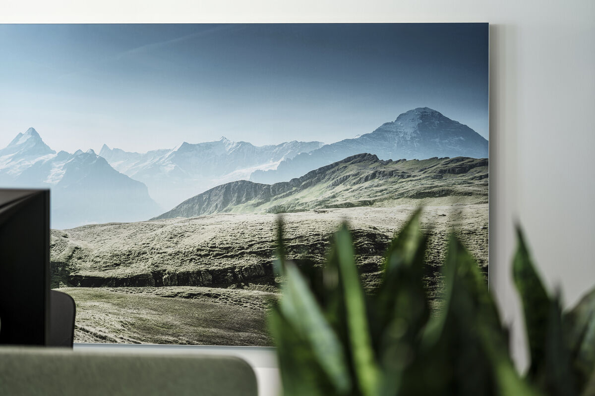 Alu Line Wall Akustikbild mit bedrucktem grünem Alpenmotiv und Alurahmen als Schallschutz an der Wand