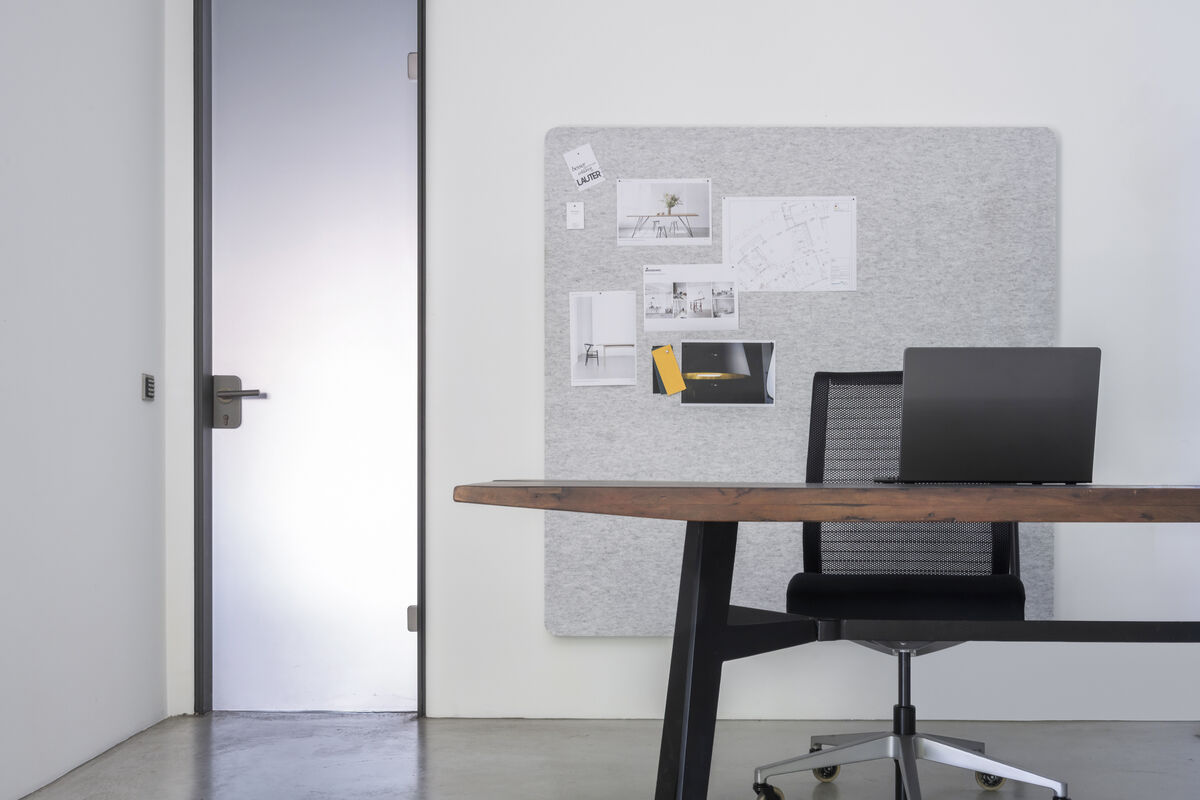Frameless Wall graues rahmenloses Akustik-Wandpaneel als pinnbare Pinnwand mit Notizen hinter einem Schreibtisch, Seitenansicht