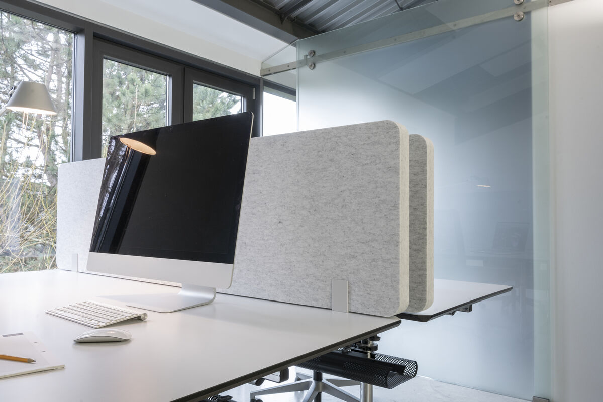 Frameless Table graue rahmenlose Akustik-Tischtrennwand als Sichtschutz hinter einem iMac am Schreibtisch vor der Fensterfront