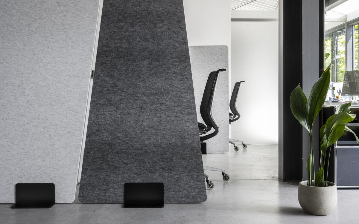 Frameless Move freistehende anthrazitfarbene trapezförmige Akustik-Stellwand mit Standfuß als Raumteiler im Büro