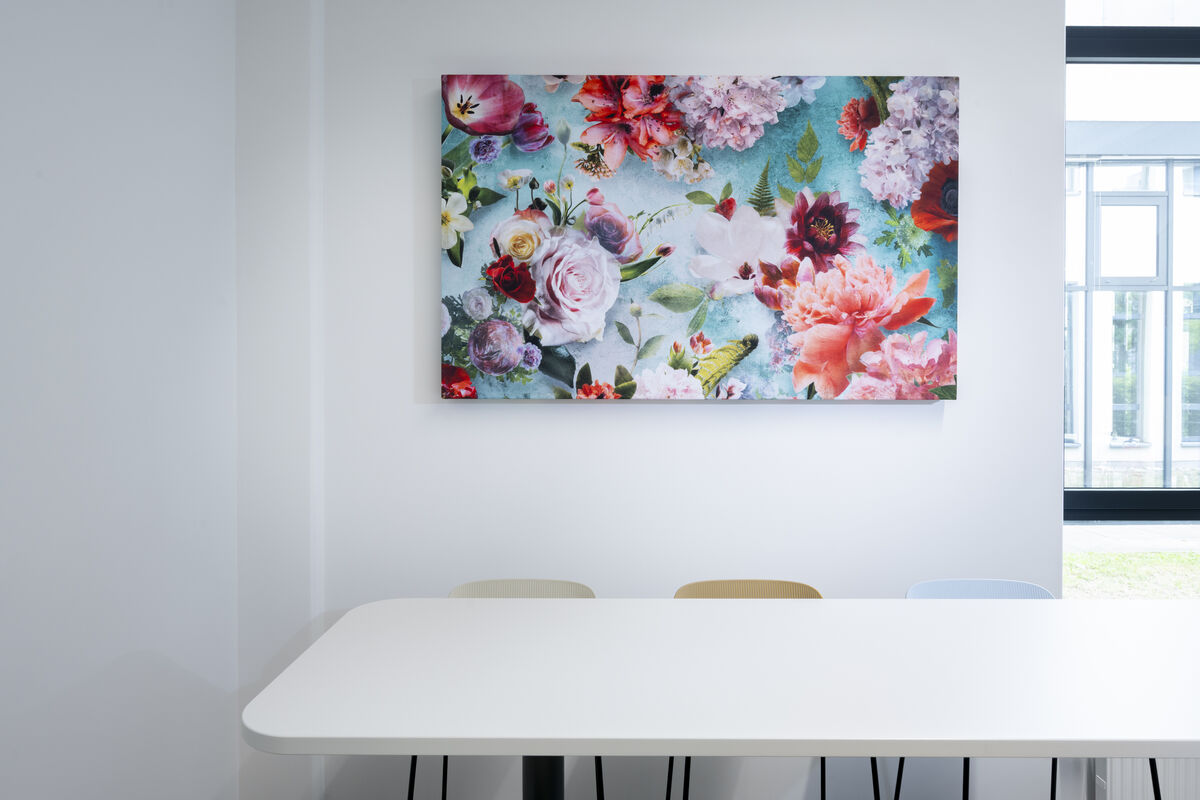Frameless Picture rahmenloses Akustikbild mit bedrucktem bunten Blumenmotiv als Schallschutz über einem Esstisch im hellen Raum