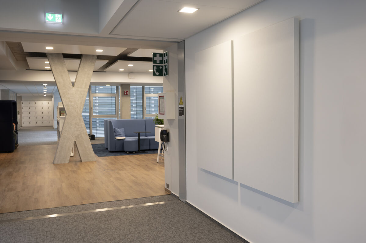 Frameless Wall zwei weiße rahmenlose Akustik-Wandpaneele als Schallschutz an einer Wand im Eingangsbereich mit Loungezone
