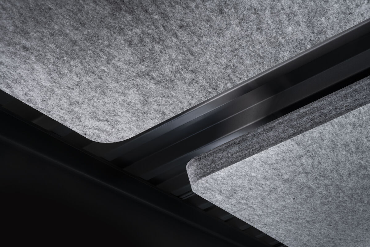 Frameless Sky Detailaufnahme grauer Akustik-Deckensegel mit schwarzem Verbindungssteg vor Sichtbeton