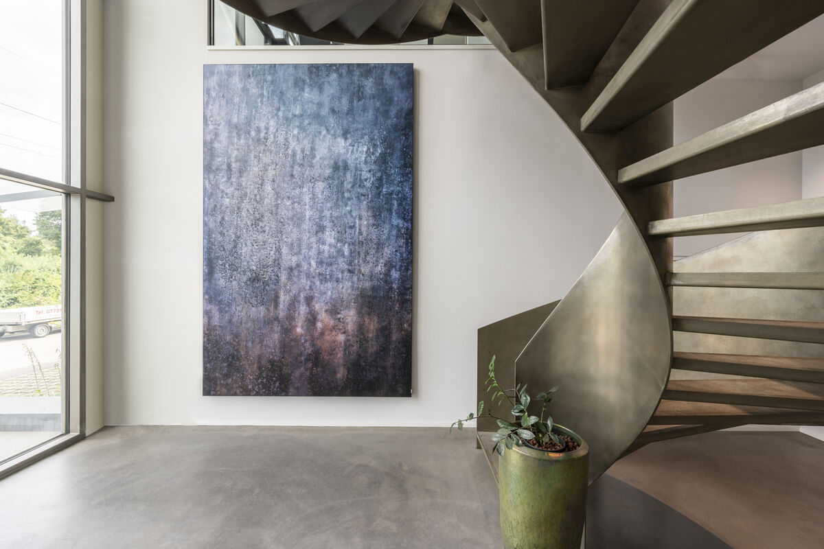 Alu Line Wall hochformatiges Akustikbild mit abstraktem blauem Motiv als Schallschutz neben einer Wendeltreppe