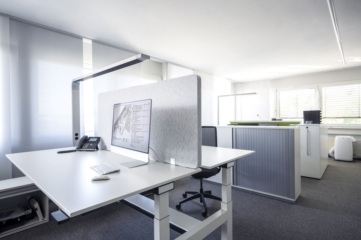 Frameless Table Nahaufnahme einer grauen rahmenlosen Akustik-Tischtrennwand mit Standfuß und Kabel am Schreibtisch