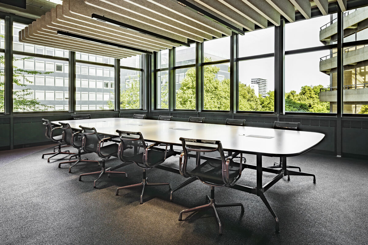 Frameless Baffle schwarze abgehängte Akustik-Baffles als Schallschutz über einem Konferenztisch mit Fensterfront