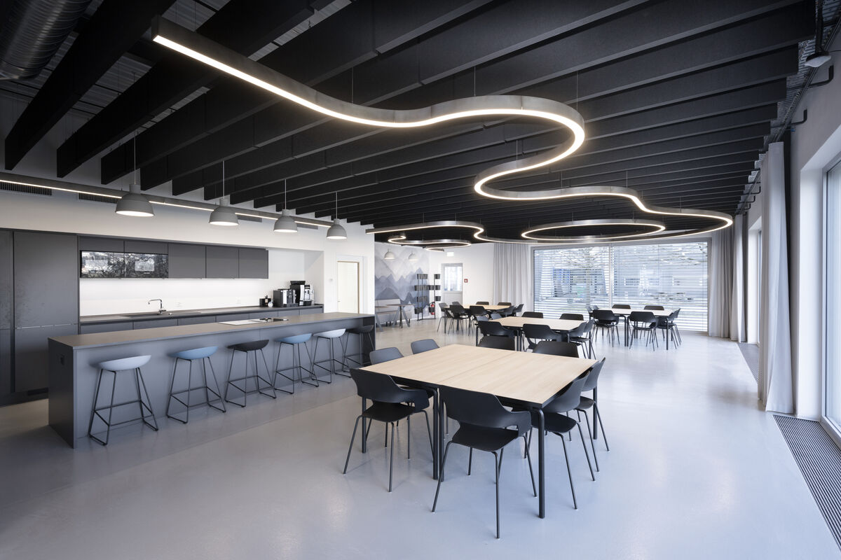 Frameless Baffle schwarze abgehängte Akustik-Baffles mit runden Lichtelementen als Schallschutz in einer Kantine