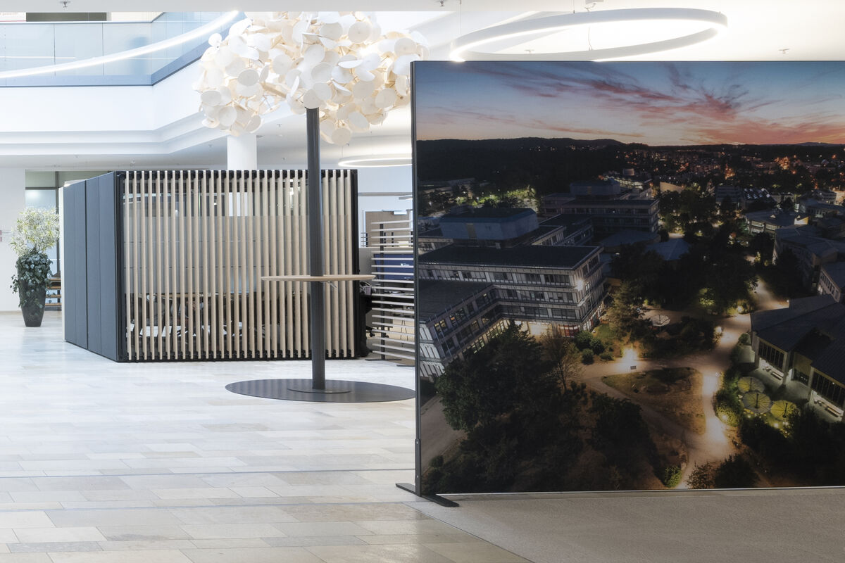 Alu Line Move freistehender Akustik-Raumtrenner mit großformatigem Luftbild-Motiv als Sichtschutz im Foyer