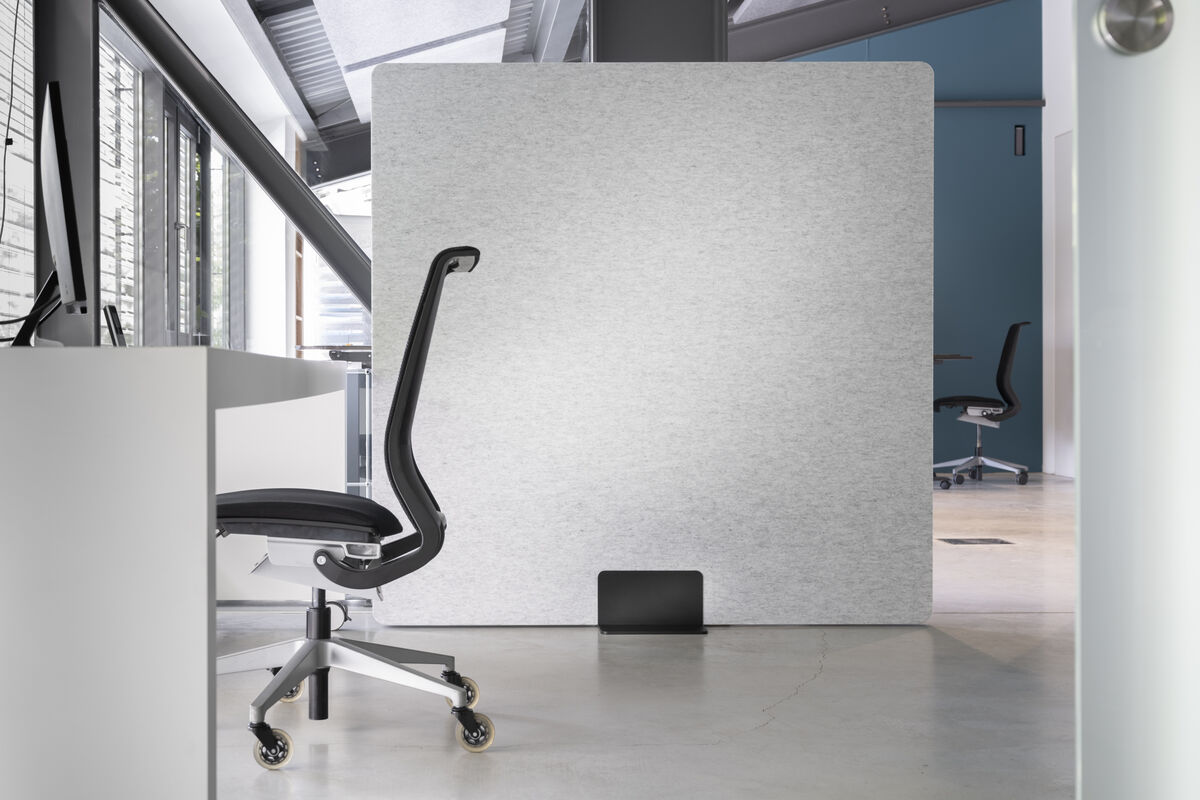Frameless Move freistehende Akustik-Stellwand in Grau als mobiler Raumteiler und Sichtschutz neben einem Büroarbeitsplatz