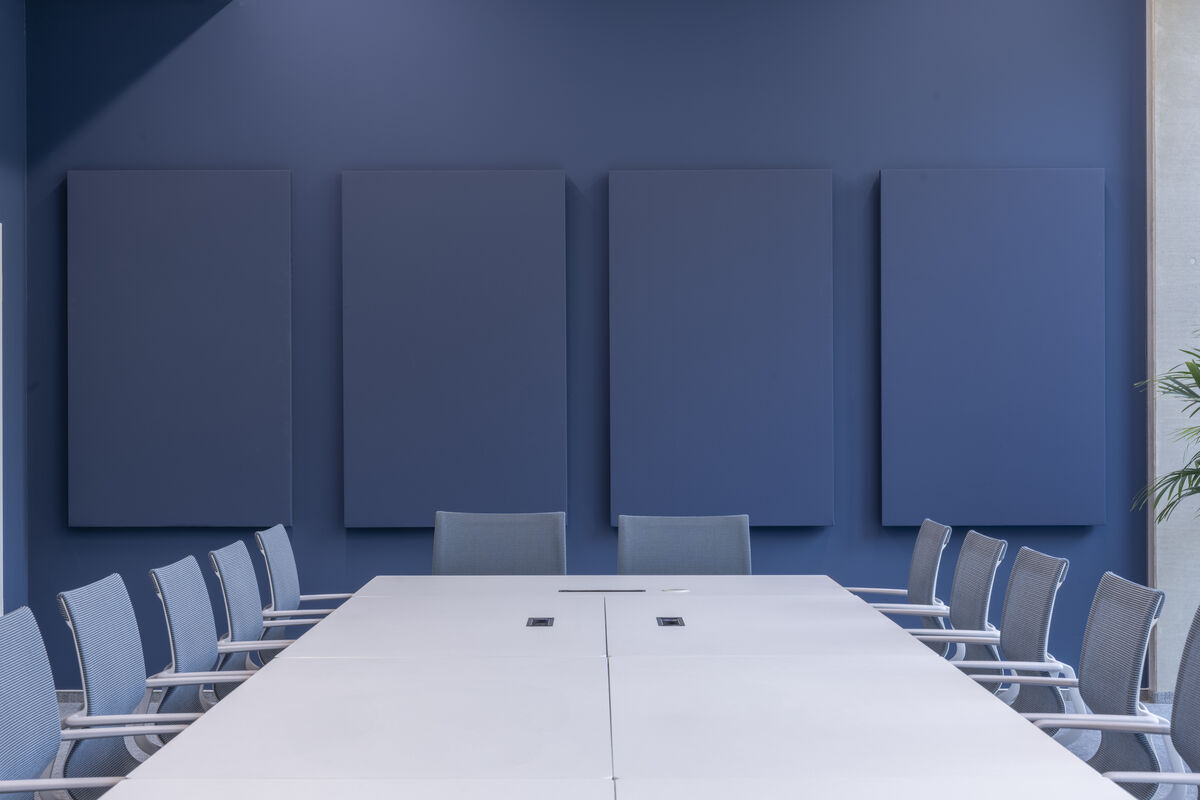Frameless Color vier hochformatige blaue farbige Akustik-Wandpaneele als Schallschutz an der Wand eines Konferenzraums
